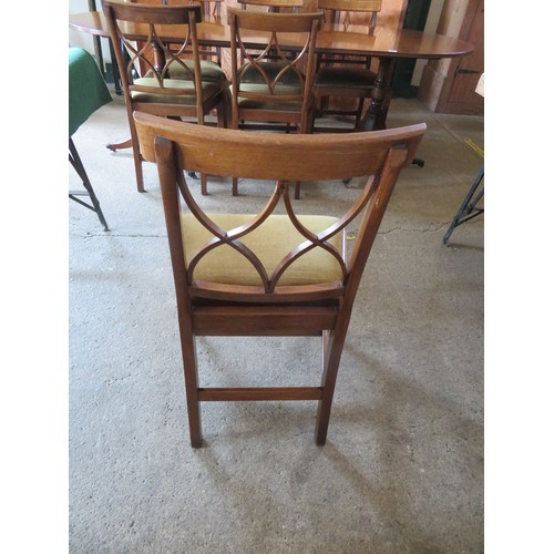 772 - An extending mahogany dining table and 6 chairs.  The table is on 2-pedestal bases with splayed legs... 