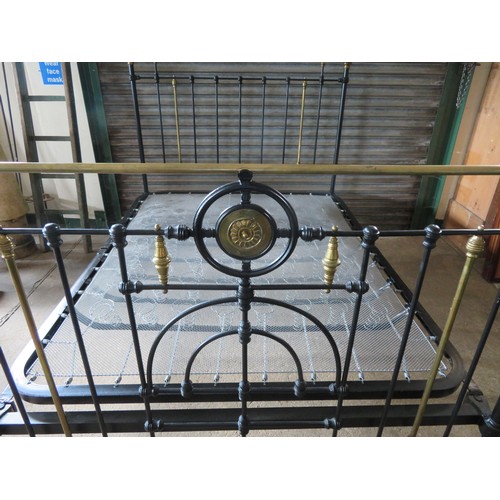 771 - An antique 5ft bedstead, painted black with ornate brass fittings.