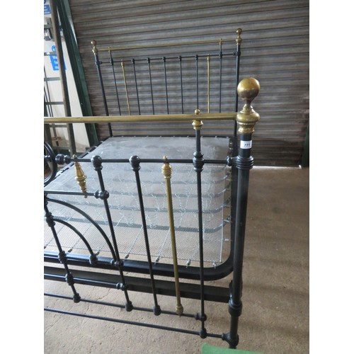 771 - An antique 5ft bedstead, painted black with ornate brass fittings.