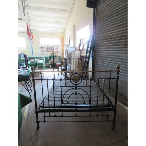 771 - An antique 5ft bedstead, painted black with ornate brass fittings.