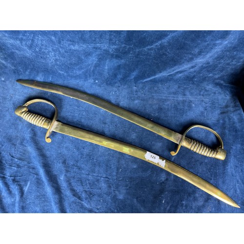 125 - A pair of brass fire irons in the shape of sabres.