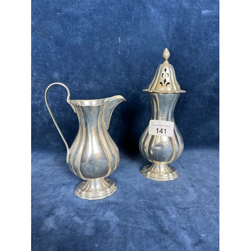 141 - A small silver jug of fluted design together with a matching sugar shaker both hallmarked Birmingham... 