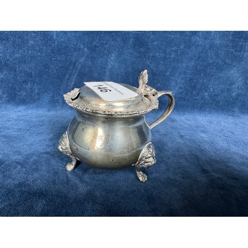 146 - A silver mustard pot with hinged lid on 3 claw feet surmounted with a Lions head and having blue gla... 