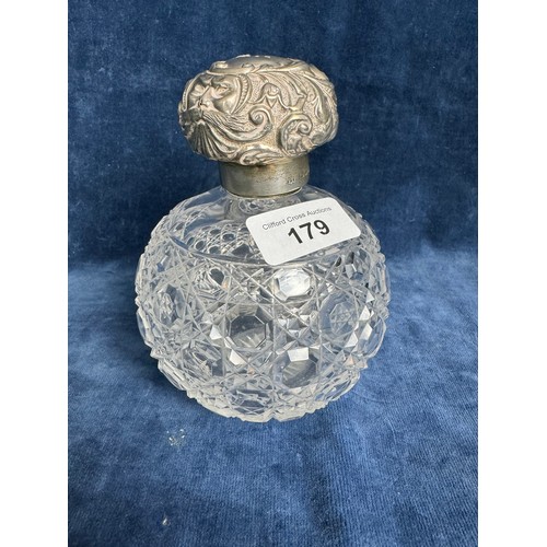 179 - A cut glass scent bottle with glass stopper and silver band and lid, hallmarked (possibly Chester)
