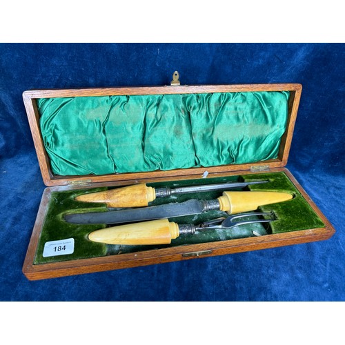 184 - The three-piece carving set in oak presentation case  with steel ends and having bone handles with s... 