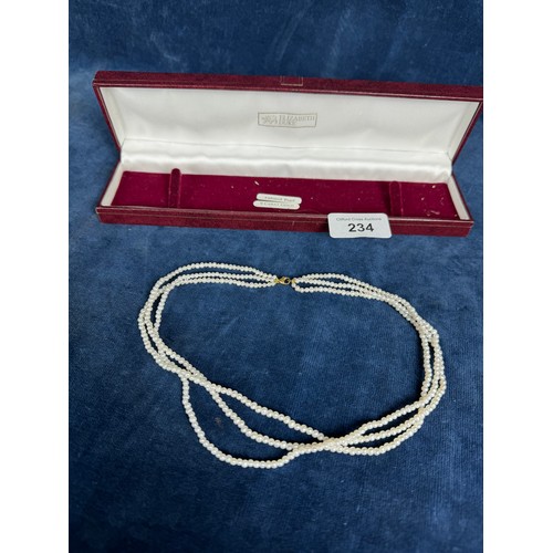 234 - A three string set of cultured pearls with a 9 carat gold clasp in a presentation case.