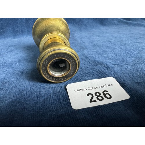 286 - An extendable brass opera glass of plain design marked around eyepiece 