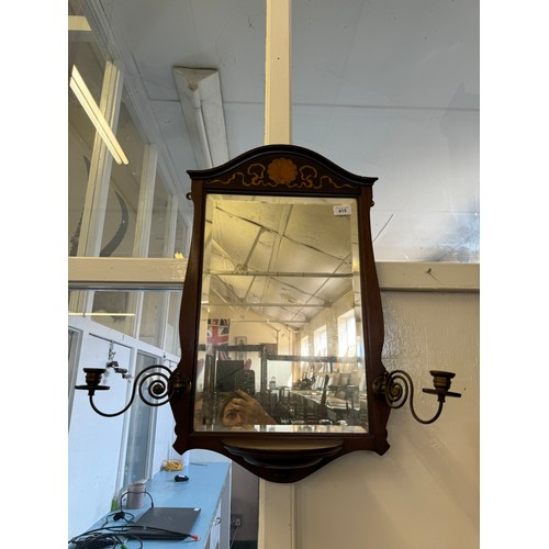 415 - An Edwardian mahogany wall mirror with inalid shell and ribbon decoration having candlestick sconces... 