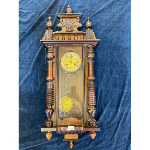 423 - An antique oak cased wall clock with brass dial and pendulum having turned column sides