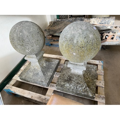 27 - A pair of ball shaped gate post finials on square and shaped bases.  Base 43cm x 43cm, total height ... 