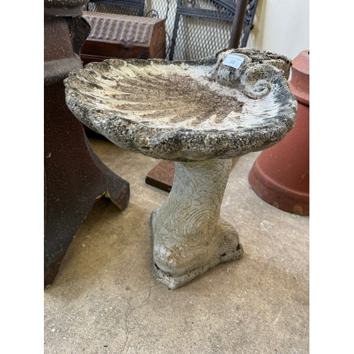 34 - A concrete bird bath having a fish pedestal shaped base.