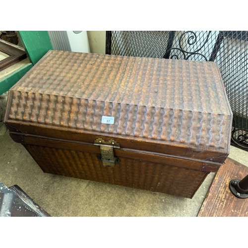 37 - A travelling tin trunk with ribbed finish to front, back and top, having a brass locking catch marke... 