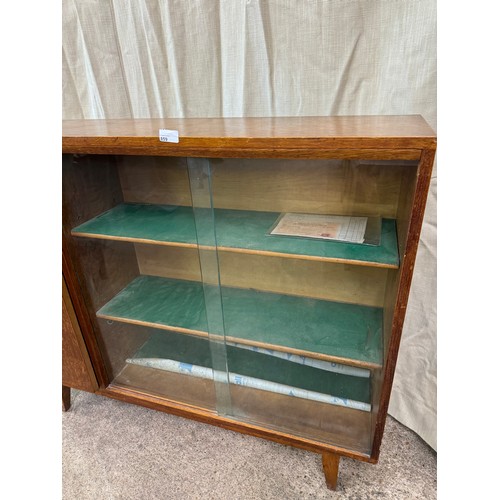 859 - A solid oak bookcase made by Heal & Son Ltd, London having 2 glazed sliding doors with 2 adjustable ... 