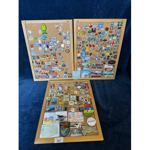 421 - Three cork boards containing a large quantity of pin badges and magnets of various location for UK a... 