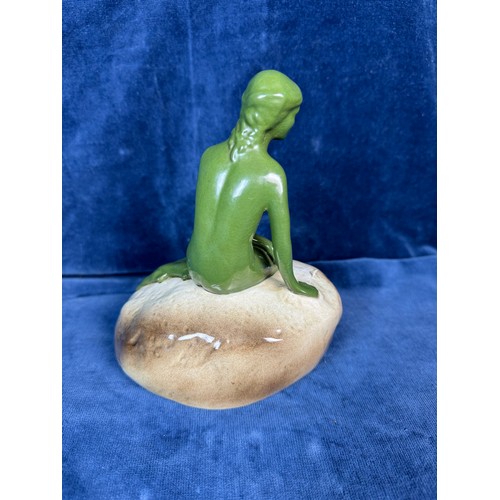 106 - A pottery figure of a green lady seated on rock advertising 'Carlsberg'.