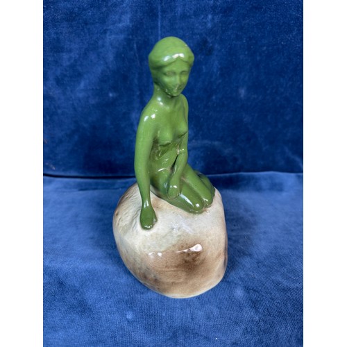 106 - A pottery figure of a green lady seated on rock advertising 'Carlsberg'.