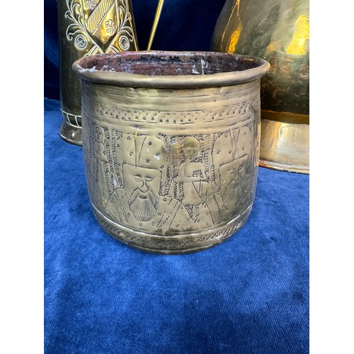 384 - A large brass vase with hammered design, a brass jug having Fleur de Lys style shield, together with... 