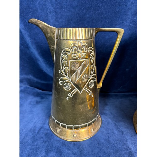 384 - A large brass vase with hammered design, a brass jug having Fleur de Lys style shield, together with... 