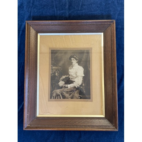 23 - A framed black and white photograph of a lady seated.