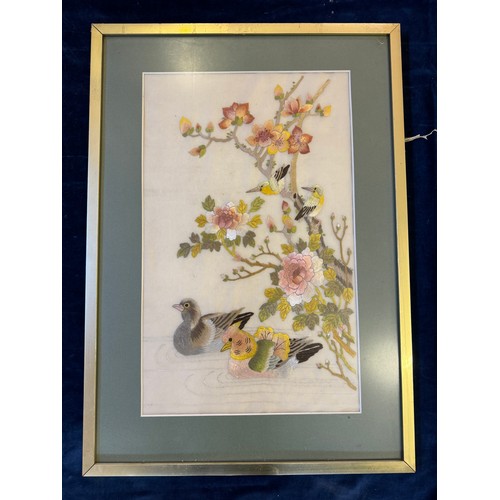 64 - A framed Oriental inspired tapestry depicting birds.