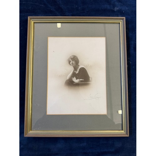 61 - A framed black and white photograph of a seated lady with signature Lilian Ream.