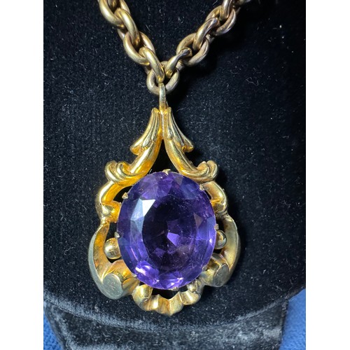 200 - A 9ct gold chain with gold metal pendant having large cut purple Amethyst style stone, the whole inc... 