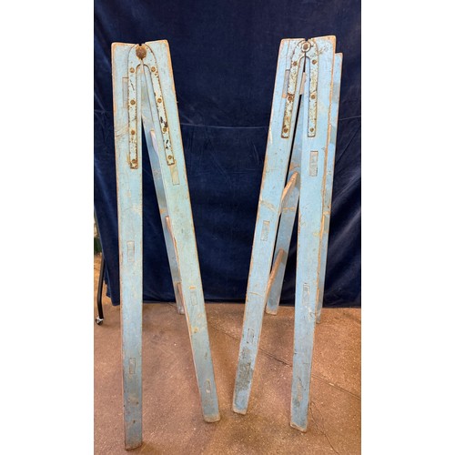 18 - A vintage pair of wooden trestles, having metal hinges, painted in sky blue colour.