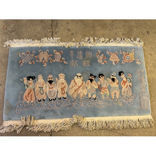 33 - A 20th century wool rug, having Japanese gentlemen and oriental decoration.