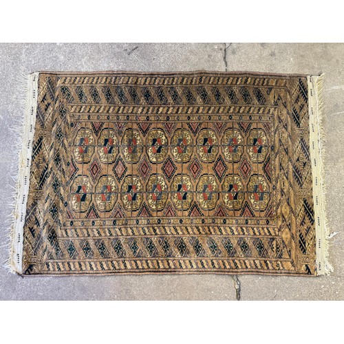 34 - A small woven rug with coloured lozenge decoration and tassled ends.