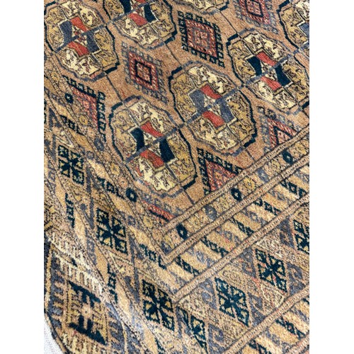 34 - A small woven rug with coloured lozenge decoration and tassled ends.