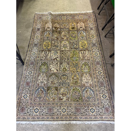 35 - A large woven  rug in the oriental style with square sectioned centre depicting pots and animals etc... 