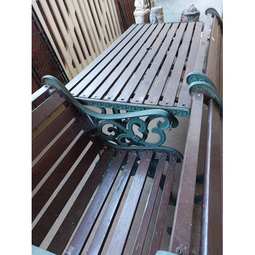 23 - CAST IRON AND WOODEN GARDEN SET COMPRISING BENCH, TABLE AND A PAIR OF GARDEN CHAIRS