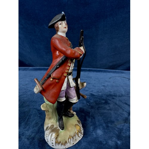 216 - A pair of Dresden porcelain figures depicting a huntsman with rifle and a dog, and a lady holding a ... 