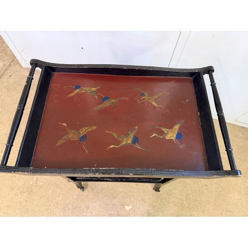 449 - An ebonised tea trolley in the oriental design, having hand painted bird decoration, with a removabl... 