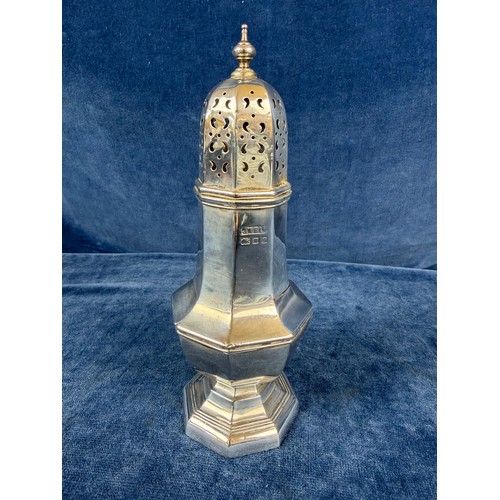 100 - A silver sugar shaker of plain design and pierced top, hallmarked London 1933-1934, makers mark J. W... 