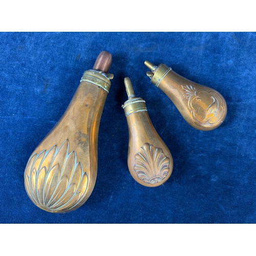 320 - Three antique copper and brass gunpowder flasks.