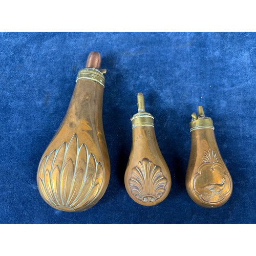 320 - Three antique copper and brass gunpowder flasks.