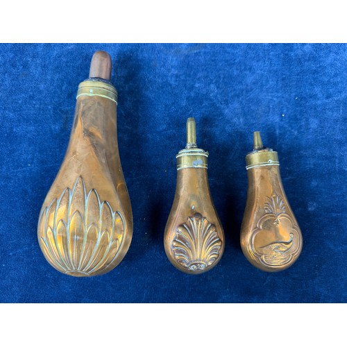 320 - Three antique copper and brass gunpowder flasks.