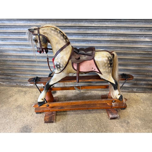 19 - An antique rocking horse with dapple grey colouring and horse hair mane and tail on pitched pine bas... 