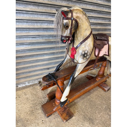 19 - An antique rocking horse with dapple grey colouring and horse hair mane and tail on pitched pine bas... 