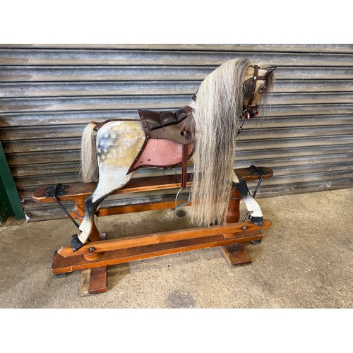 19 - An antique rocking horse with dapple grey colouring and horse hair mane and tail on pitched pine bas... 