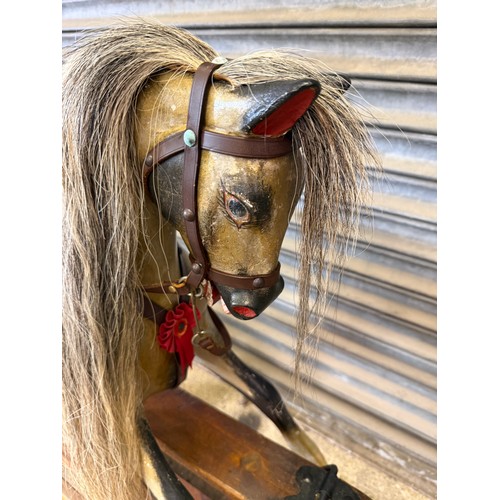 19 - An antique rocking horse with dapple grey colouring and horse hair mane and tail on pitched pine bas... 