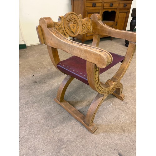 461 - An oak framed carved chair in the style of a savonarola chair, on an 'X' framed base.