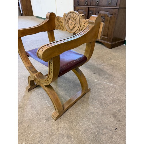 461 - An oak framed carved chair in the style of a savonarola chair, on an 'X' framed base.