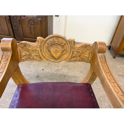 461 - An oak framed carved chair in the style of a savonarola chair, on an 'X' framed base.