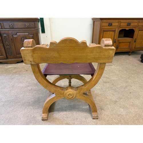 461 - An oak framed carved chair in the style of a savonarola chair, on an 'X' framed base.
