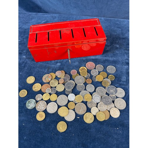 187 - A retro metal home savings thrift tin money box containing a quantity of coins from around the world... 