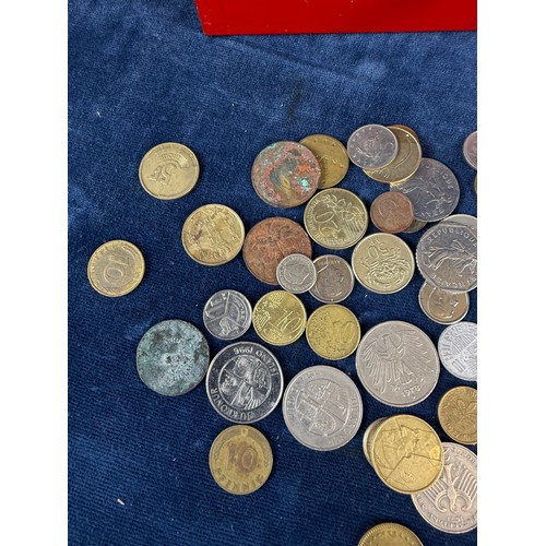 187 - A retro metal home savings thrift tin money box containing a quantity of coins from around the world... 