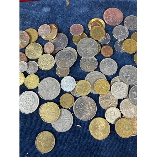 187 - A retro metal home savings thrift tin money box containing a quantity of coins from around the world... 