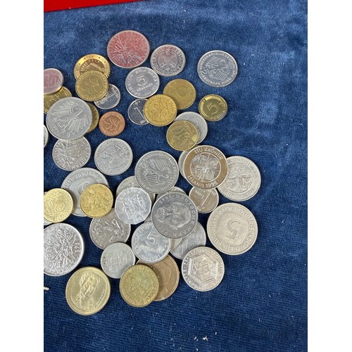 187 - A retro metal home savings thrift tin money box containing a quantity of coins from around the world... 